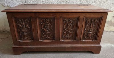 un vieux coffre en bois orné de sculptures sur la façade