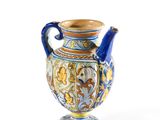 un vase bleu et jaune posé sur une surface blanche