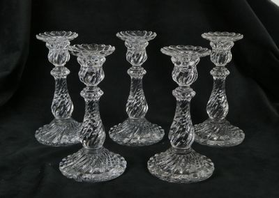 trois bougeoirs en verre transparent posés sur un tissu noir