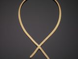 a gold necklace on a black background