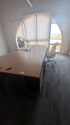 une photo d'une salle de réunion vide, avec un bureau et des chaises