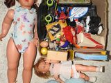 deux poupées et une peluche par terre