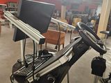 an image of a gym room with a treadmill and a monitor