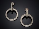 a pair of diamond earrings, by person