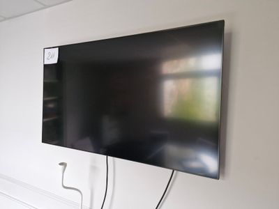 un téléviseur à écran plat fixé au mur d'une pièce