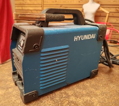 une image représentant une machine bleue et noire posée sur une table
