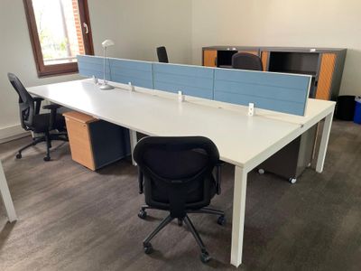 a white desk with a blue divider and a black chair