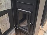 a black stove sitting on a pallet in a room