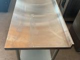 a stainless steel table in the middle of a kitchen