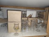 de nombreux verres à vin vides posés sur une étagère dans une pièce