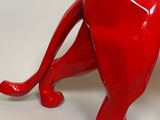 a red cat figurine sitting on a white surface