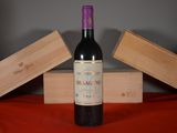 a bottle of wine sitting on a table next to two wooden boxes
