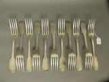 six fourchettes et six cuillères sont disposées en rangée sur une table