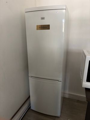 un réfrigérateur blanc et un micro-ondes dans une petite pièce