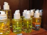 several bottles of oil are lined up on a shelf in a bathroom
