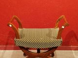 a small wooden bench with a black and white checkered seat