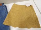 two pairs of jeans and a knitted skirt are on display