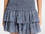 une femme vêtue d'un haut noir et d'une jupe bleue