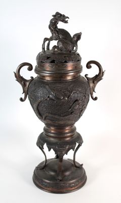 a bronze vase with a dragon on top of it