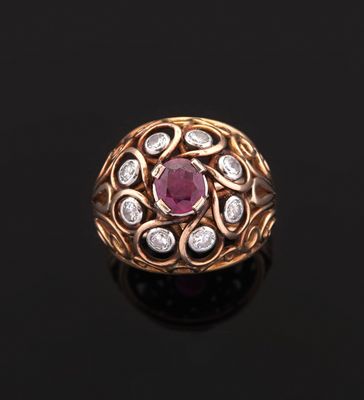 a close up of a gold ring with a ruby and diamond center