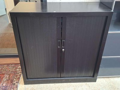 une armoire noire à deux portes, munie d'une poignée de porte