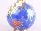 un vase bleu orné de fleurs dorées et rouges