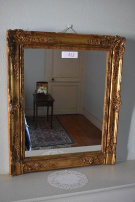 a mirror sitting on a mantle in the corner of a room