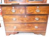 une commode en bois avec de nombreux tiroirs et une porte vitrée
