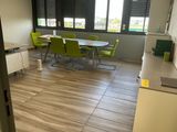 a room with a table, chairs, and a refrigerator in it