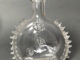 a clear glass bottle with a design on it