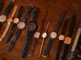 many different types of watches displayed on a wooden table