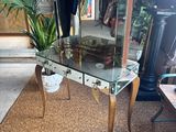 a glass table with a mirror on it and a potted plant on it