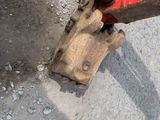 a red excavator that is sitting on the side of the road
