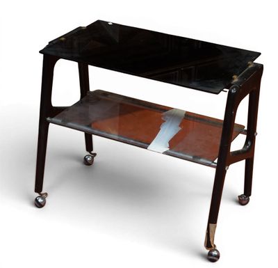 une table noire avec un plateau en verre, montée sur roulettes
