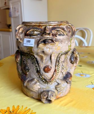 a vase with a face on it sitting on a table