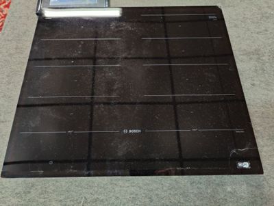 une plaque de cuisson noire surmontée d'un écran numérique