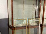 three glass display cases with brass trims and a wooden top