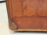 a brown suitcase sitting on the floor on the floor
