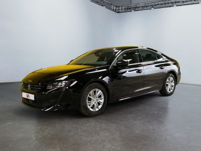 La voiture noire est garée dans la grande salle du bâtiment.