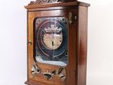 une horloge en bois surmontée d'une couronne