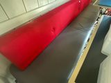 un banc sur lequel est posé un coussin rouge, dans une pièce