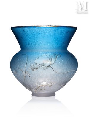 un vase en verre bleu orné d'un motif floral