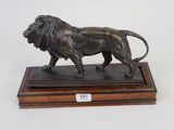 statue of a lion on a wooden base on a white background