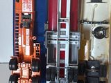 trois trains miniatures assis l'un à côté de l'autre sur une table