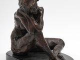 bronze statue of a woman sitting on a black base with her hands on her face