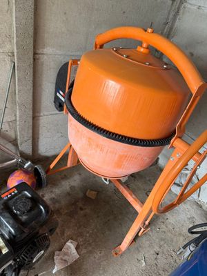 une bétonnière orange garée à côté d'une voiture bleue