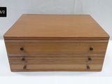 a small wooden box with three drawers on top of it