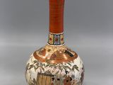 a vase with a painting on it sitting on a table