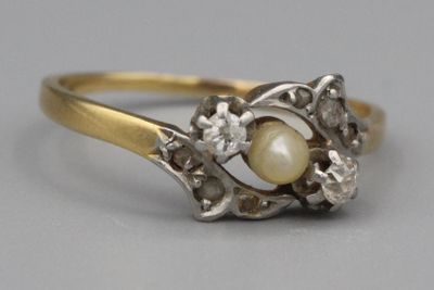un gros plan d'une bague sertie d'une perle et de diamants