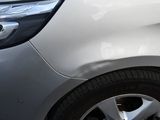 un gros plan du pare-chocs avant d'une voiture présentant une bosse